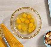 image of ten eggs cracked into a glass mixing bowl